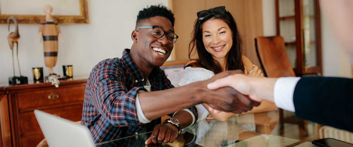 photos of a couple sign the closing documents on their new home